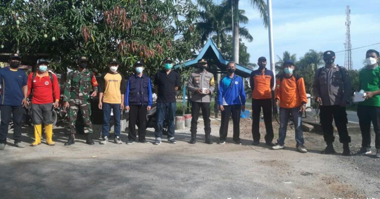 Aktifkan PPKM Skala Mikro, Babinsa Bersama Tim Tracer Parit Banjar Semprotkan Desinfektan dan Bagi Masker Gratis